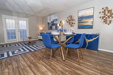 Dining area in the model unit with table and chairs next to living room at The Oasis apartments in Bossier City, LA